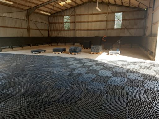 Verlegen von Reitplatzmatten in einer Reithalle